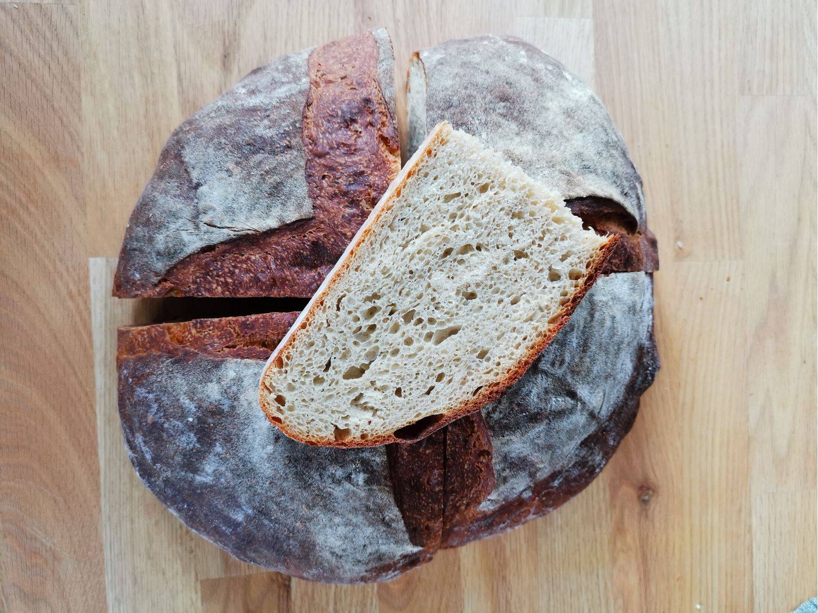 Kartoffelbrot Ein rundes Kartoffelbrot mit einer knusprigen Kruste, auf einem Holzbrett serviert.
