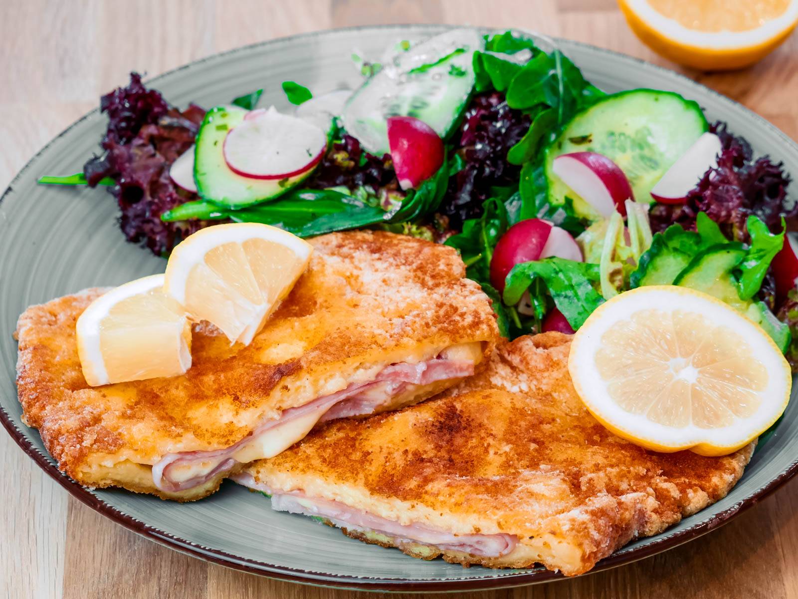 Kartoffel Cordon Bleu mit Schinken und Käse auf einem Teller mit frischem Salat