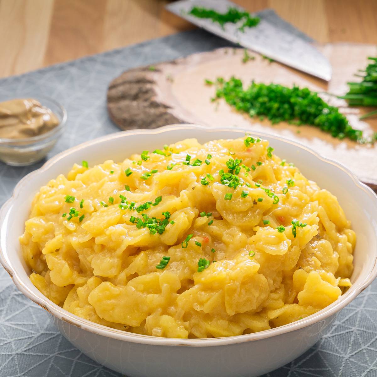 Eine Schüssel mit klassischem schwäbischem Kartoffelsalat, garniert mit frischem Schnittlauch.