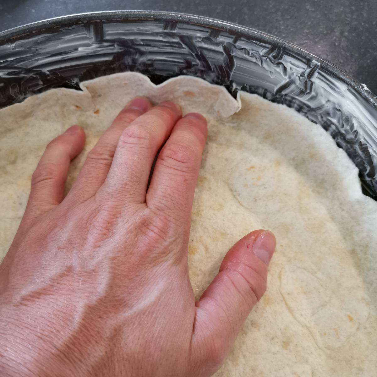Mexikanische Tortilla Lasagne – Der perfekte Wrap Auflauf für alle Tex-Mex-Fans! Tortillas werden in einer Springform ausgelegt, um die Basis für die Mexikanische Tortilla Lasagne zu bilden.