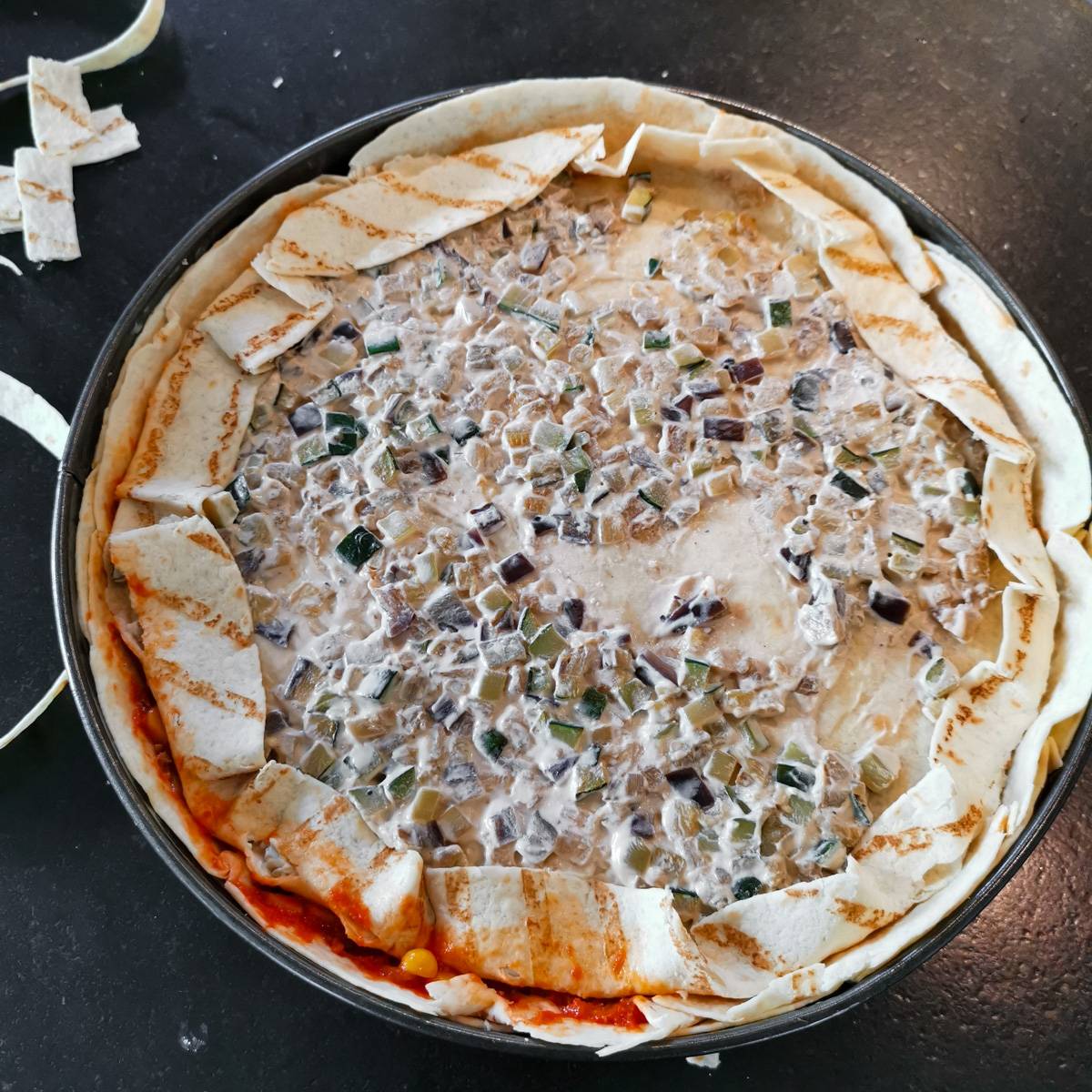 Mexikanische Tortilla Lasagne – Der perfekte Wrap Auflauf für alle Tex-Mex-Fans! Die geschichtete Mexikanische Tortilla Lasagne wird mit zusätzlichen Tortillas abgedeckt.