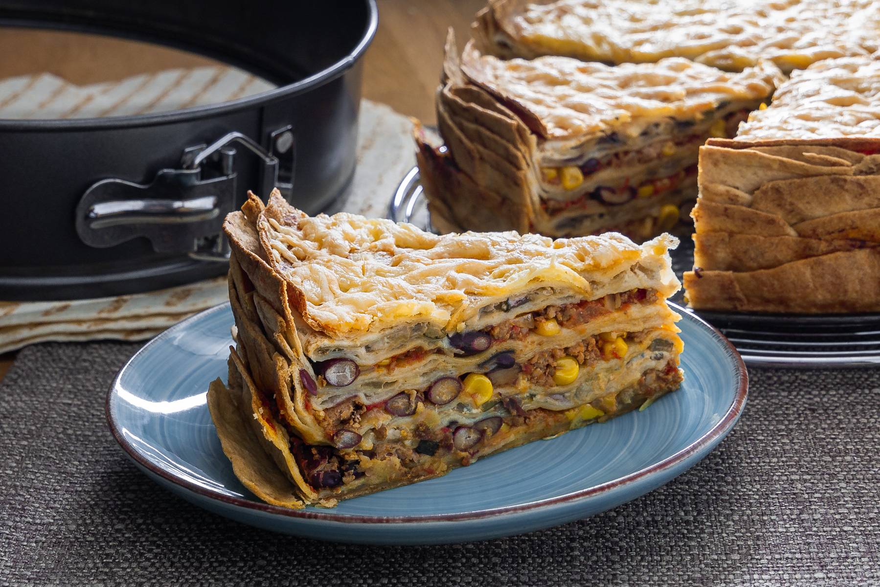 Mexikanische Tortilla Lasagne – Der perfekte Wrap Auflauf für alle Tex-Mex-Fans! Mexikanische Tortilla Lasagne in einer Springform, perfekt gebacken und serviert als Wrap Torte.